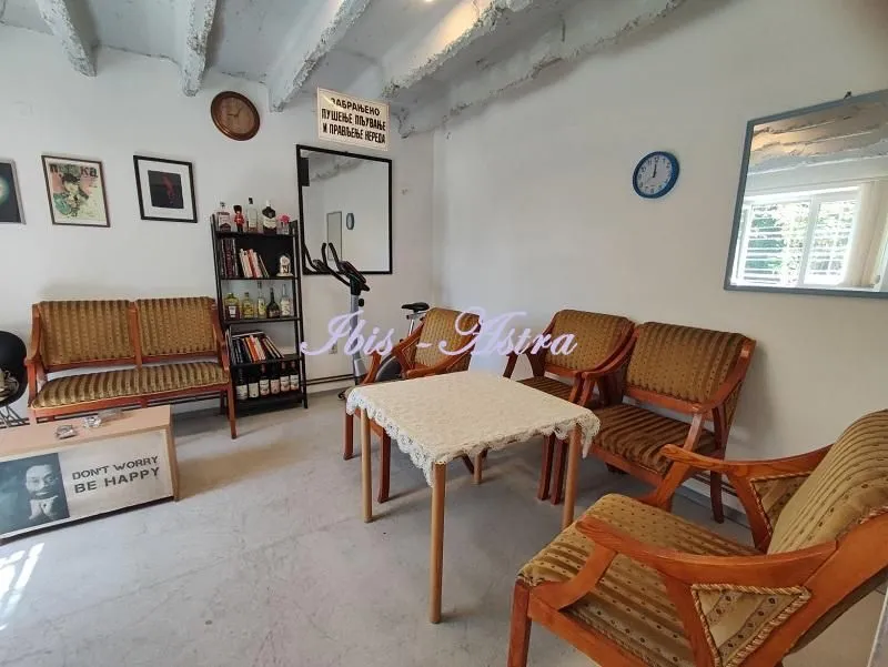 Living room with seating furniture, table and shelves.