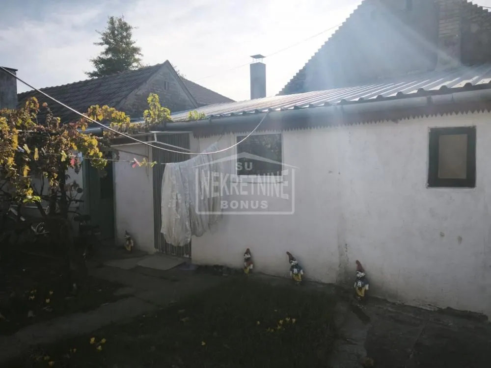 Pogled na spoljni deo kuće sa dvorištem i pomoćnim objektom.