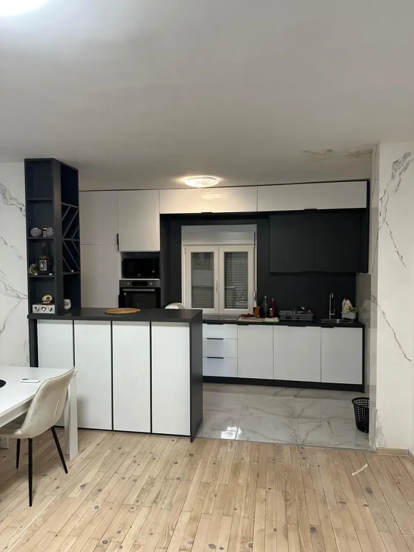 Modern kitchen with dark cabinetry and a dining area.