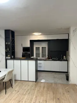 Modern kitchen with dark cabinetry and a dining area. - image 3
