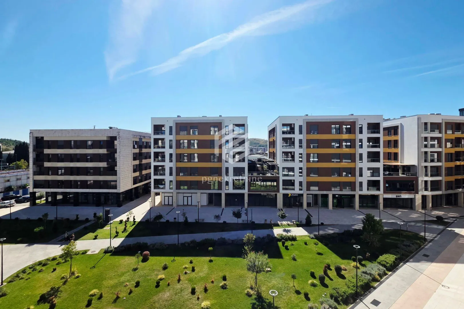 View of a modern residential complex with a landscaped courtyard.