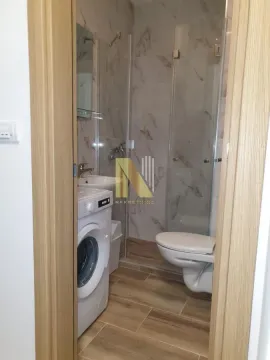 Pogled na kupatilo sa tuš kabinom, umivaonikom i veš mašinom. - image 9