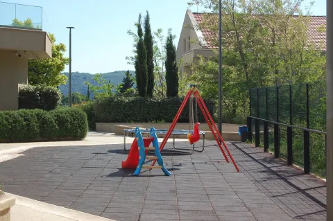Yard with a children's playground and landscaped greenery. - image 7