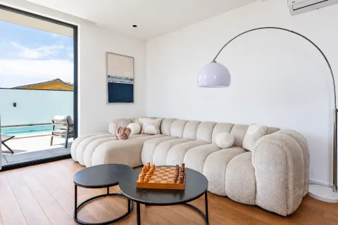 Living room with a comfortable beige sofa, coffee tables and a view of the pool. - image 9