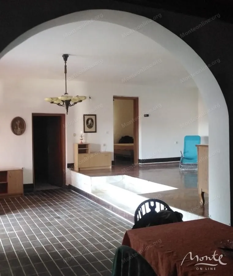 Living room with tiled floor and an arch dividing the space.
