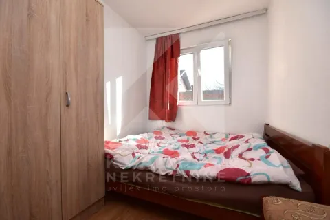 Small bedroom with a bed and a wooden wardrobe. - image 5