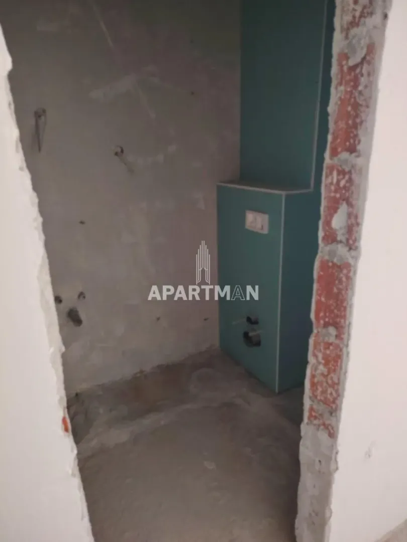 Pogled na prostoriju u fazi renoviranja sa instalacijama i zidnim oblogama.