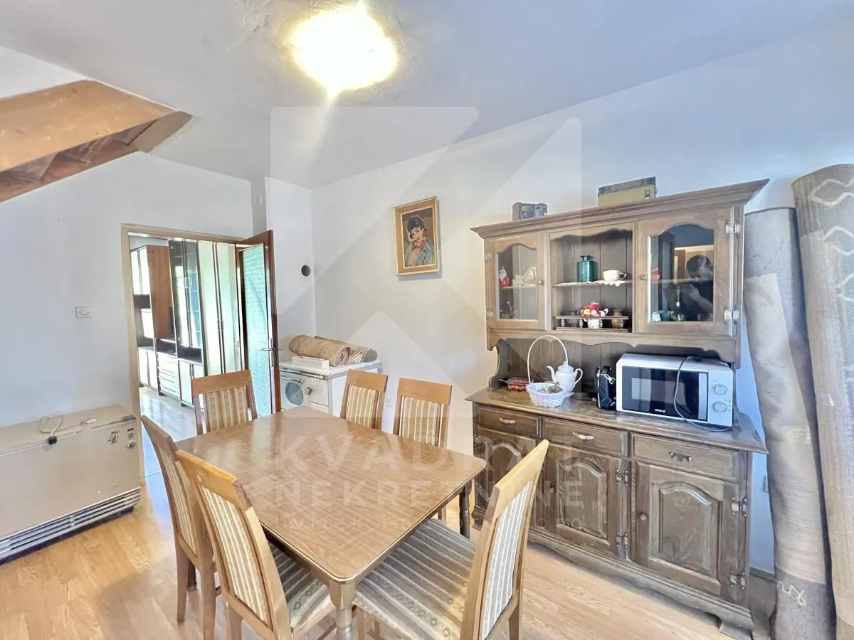 Dining room with a wooden table, chairs, and a large display cabinet.
