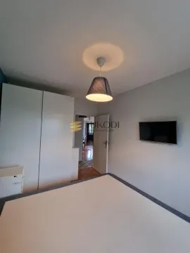 Bedroom with a bed, wardrobe, and wall-mounted TV. - image 15