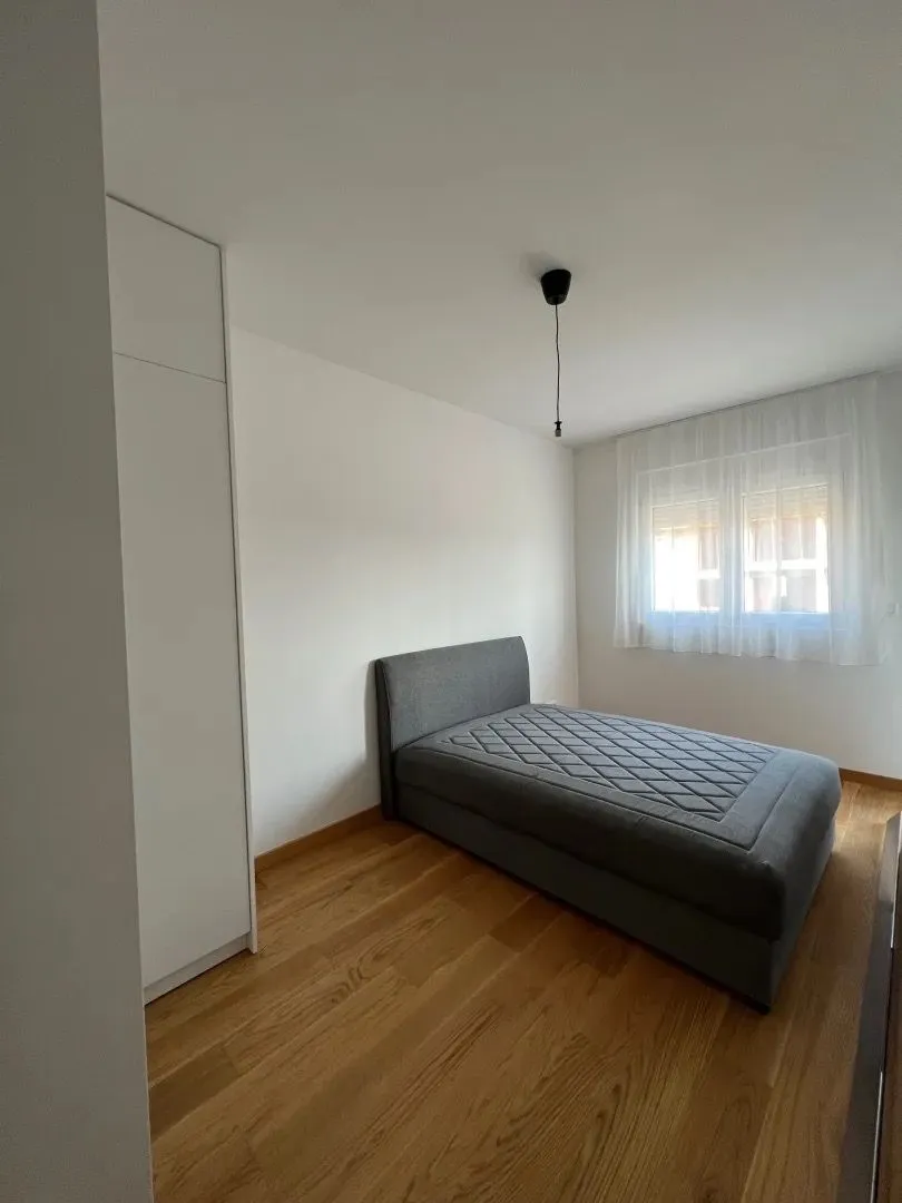 Bright and tidy bedroom with a double bed and a built-in wardrobe.