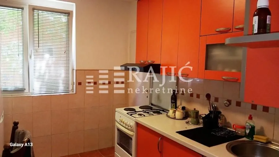 Kitchen with orange cabinets and a stove.