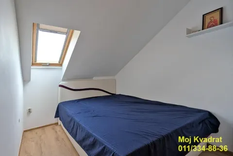 Attic bedroom with a double bed and a roof window. - image 12