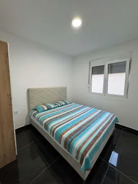 Furnished bedroom with a double bed and a window. - image 5