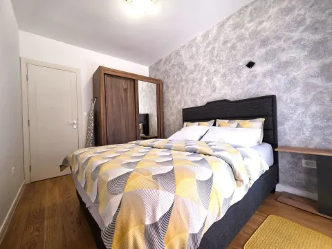 Furnished bedroom with a double bed, wooden wardrobe, and laminate flooring. - image 11