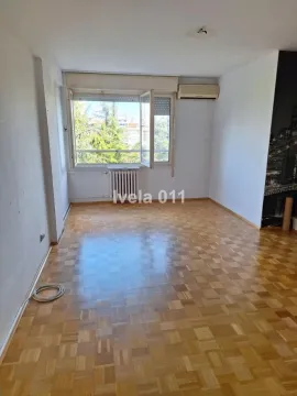Empty room with parquet flooring and a window overlooking greenery. - image 4