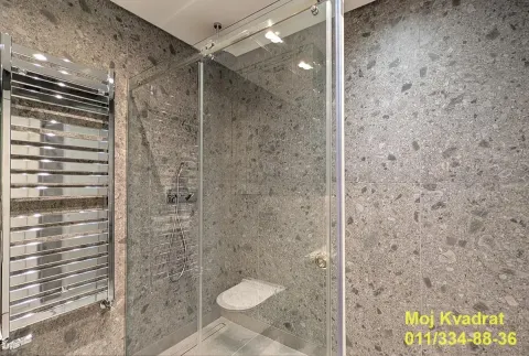 Modernly equipped bathroom with a walk-in shower and grey tiles. - image 13