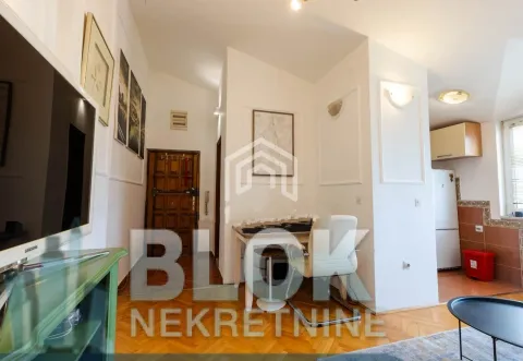 View of the living room with a desk and entrance door. - image 2