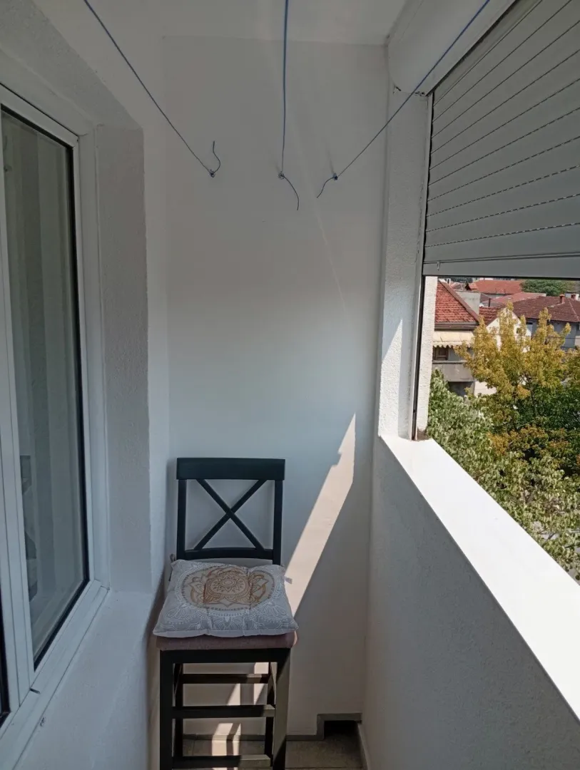 Uski balkon sa jednom stolicom.