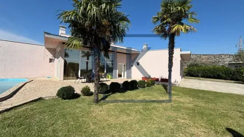 View of the yard and house facade with a swimming pool and palm trees. - image 4