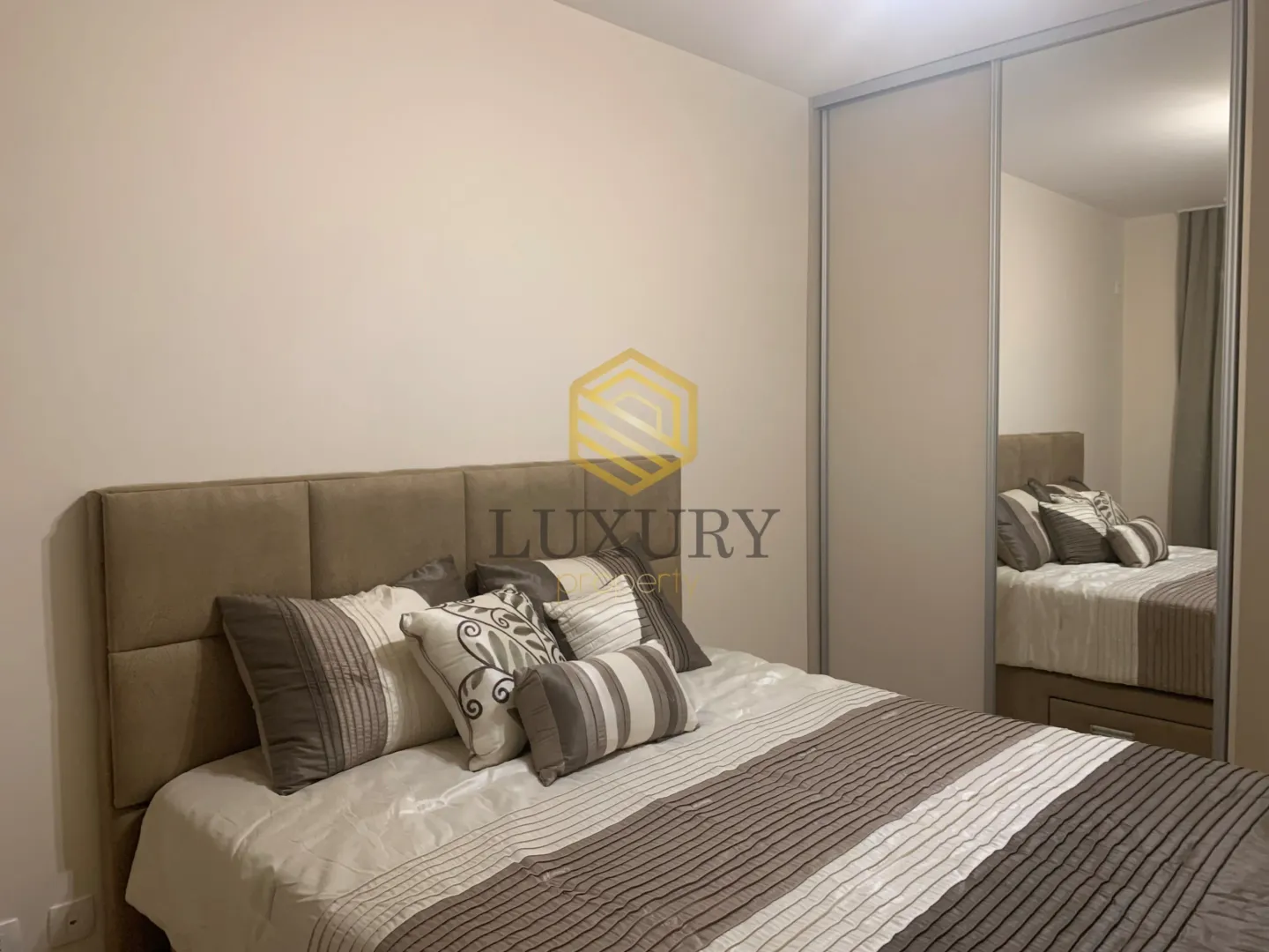 Furnished bedroom with a double bed and a built-in mirrored wardrobe.