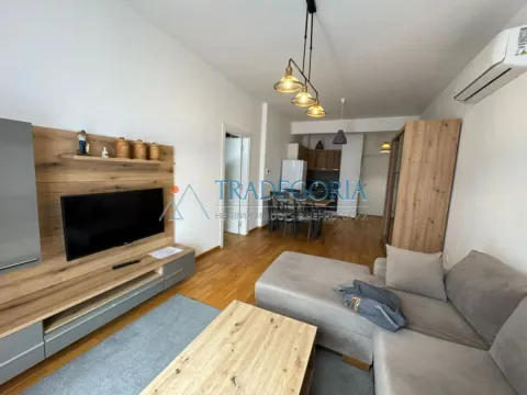 Dnevna soba sa garniturom, TV komodom i trpezarijom u pozadini. - image 2