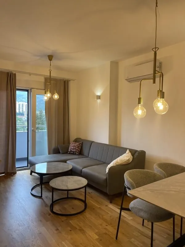 Living room with sofa, coffee tables, and terrace access.