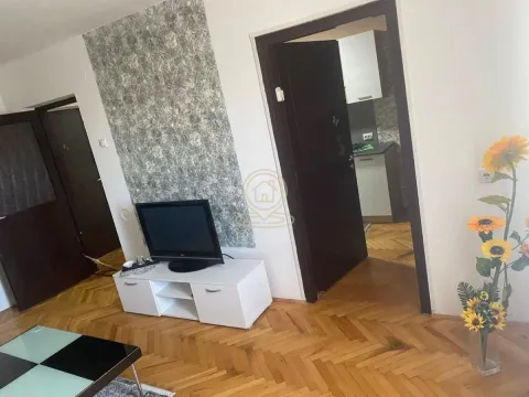 Dnevna soba sa parketom, TV komodom i dekorativnim tapetama na zidu. - image 3