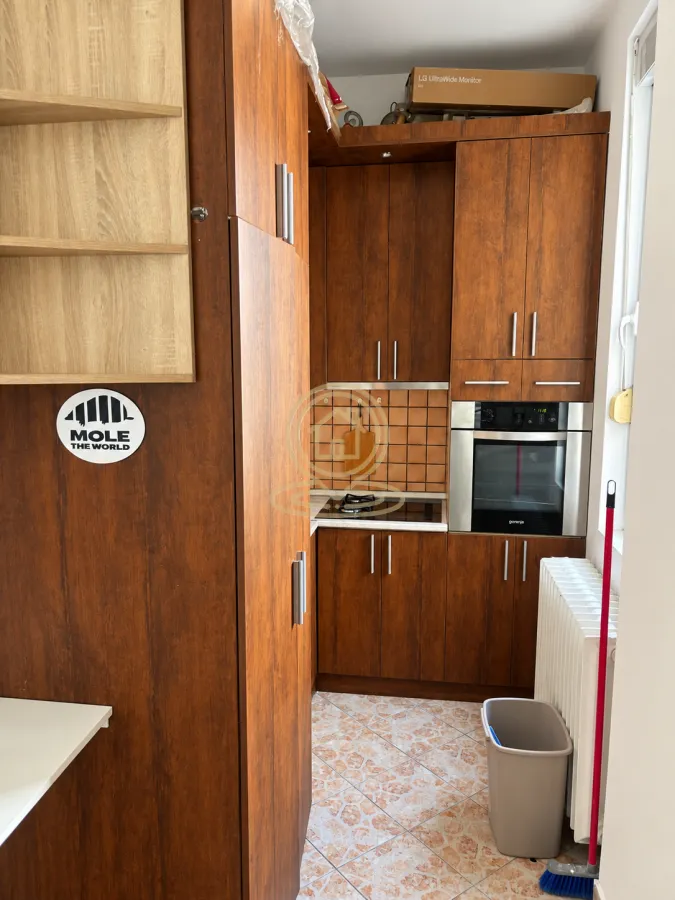 Small wooden kitchen with built-in oven and hob.