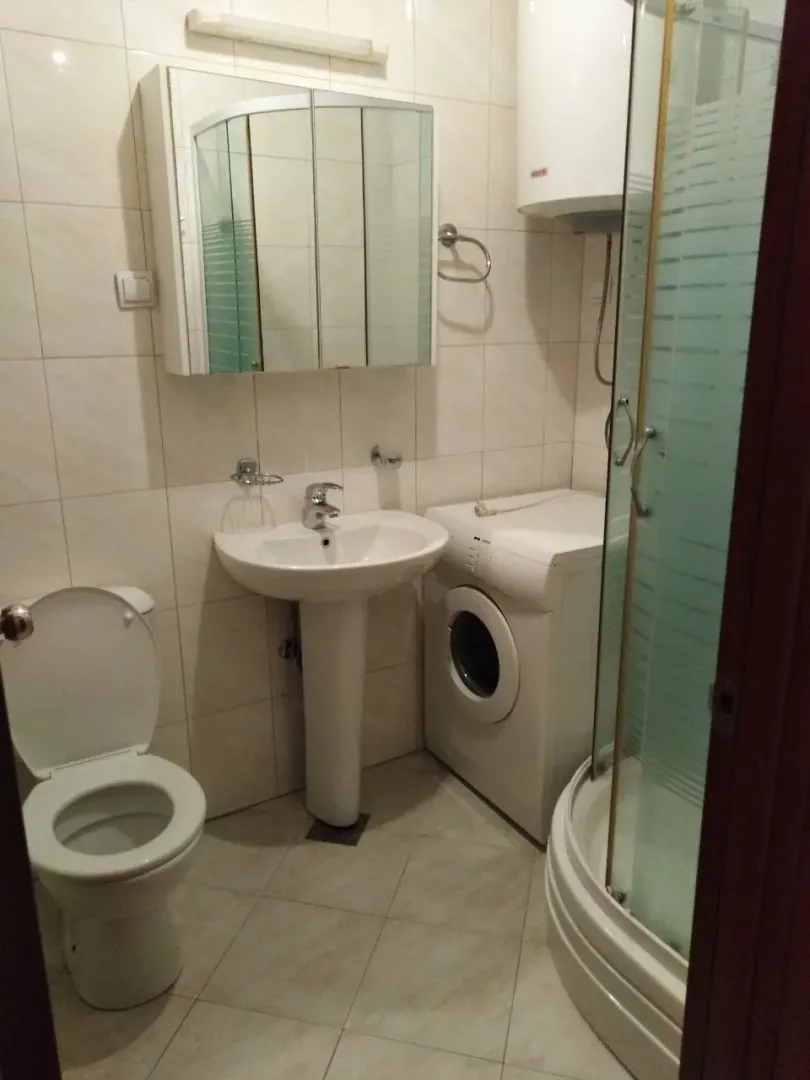 Funkcionalno kupatilo sa tuš kabinom, lavaboom i veš mašinom.