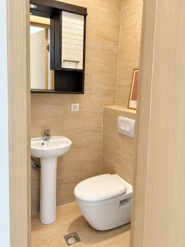 Small tiled bathroom with a washbasin and toilet bowl. - image 19