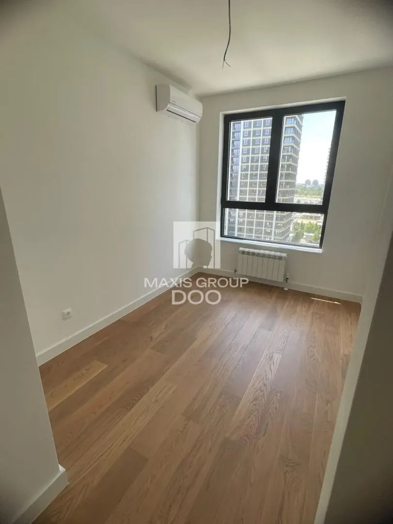 Empty room with hardwood floors and air conditioning.
