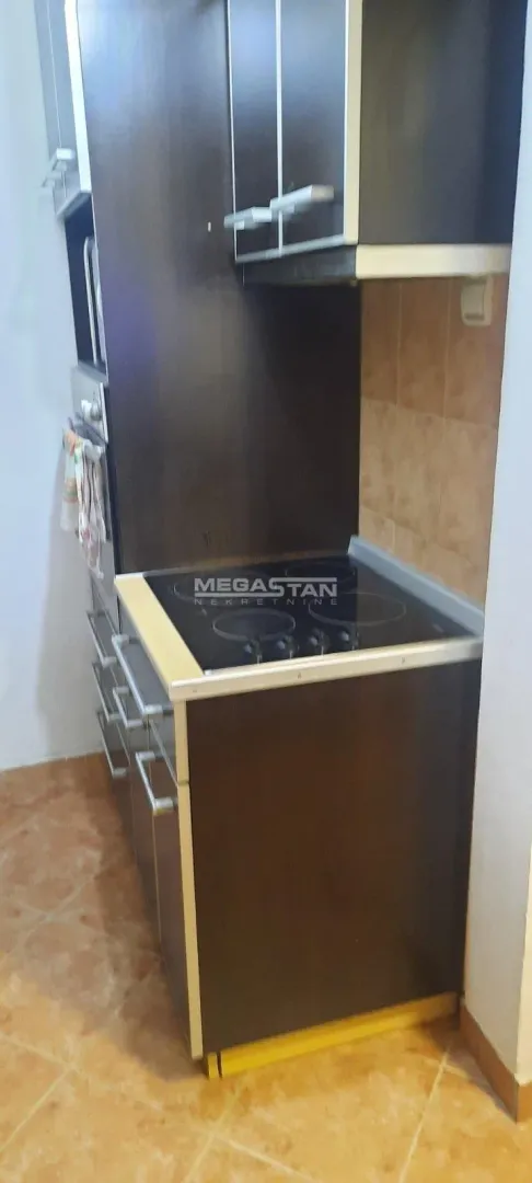 Smaller kitchen with dark cabinets and a built-in cooktop.