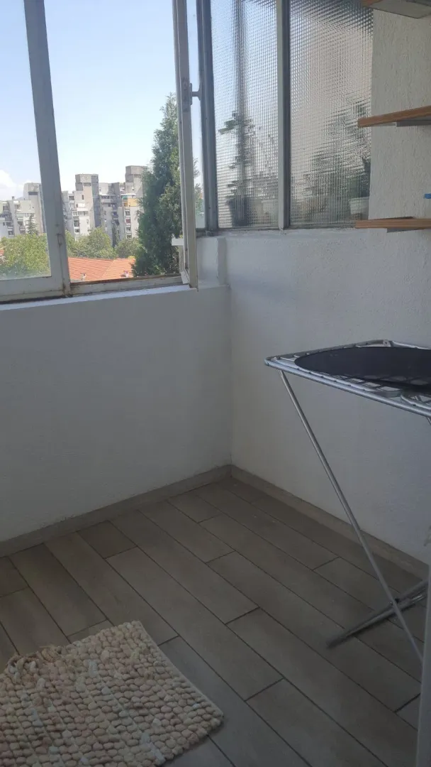 Enclosed balcony with a city view.