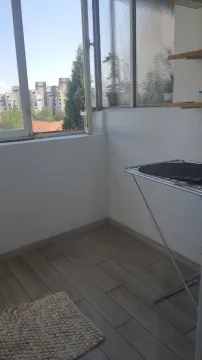 Enclosed balcony with a city view. - image 18
