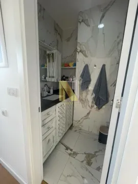 Pogled na moderno uređeno kupatilo sa mermernim pločicama i umivaonikom. - image 14