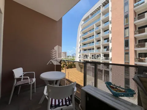 Furnished balcony with a table and chairs and a view of surrounding buildings. - image 2