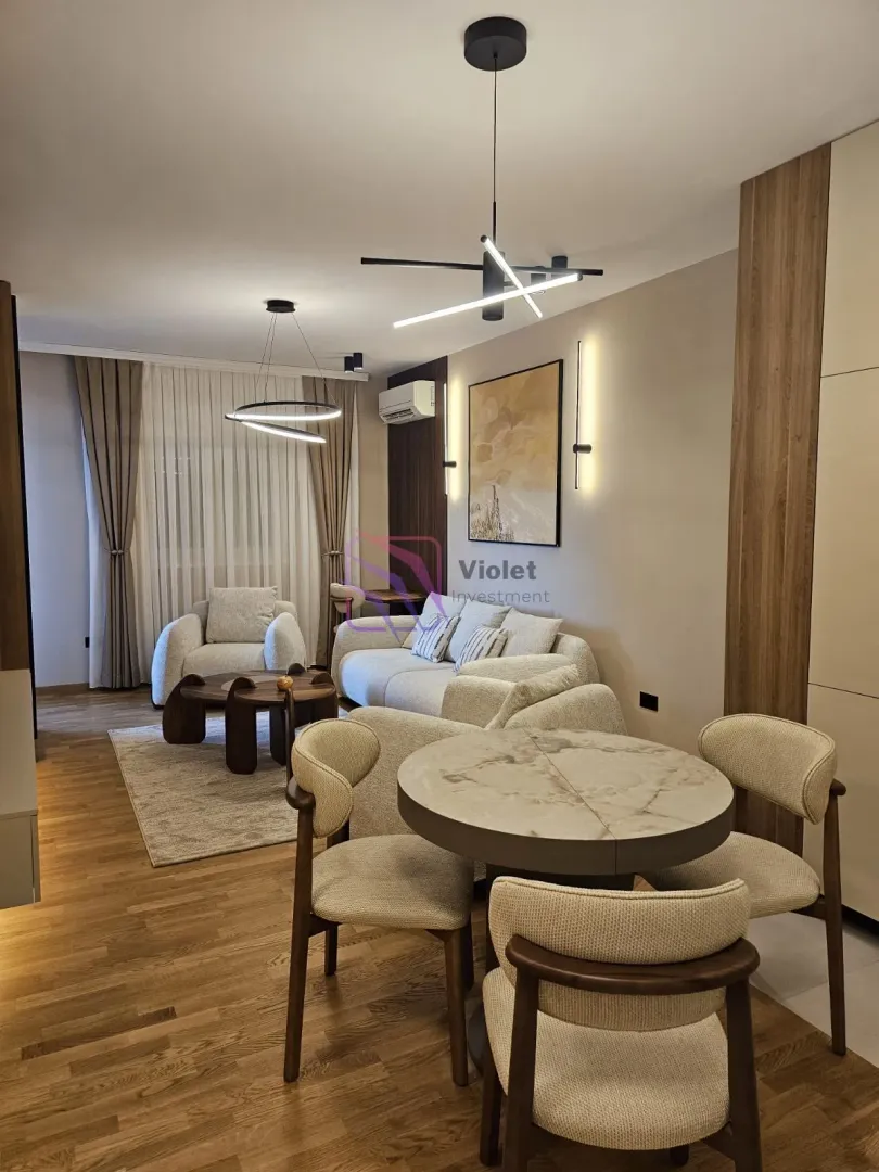 Modern living room with a sofa set, armchairs, and a dining table.