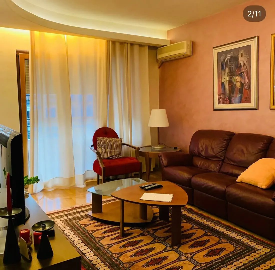 Dnevna soba sa kožnom garniturom, foteljom i trpezarijskim stolom.