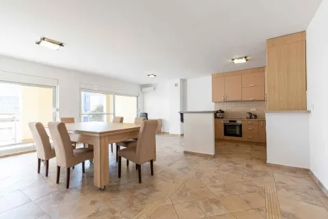 Open plan space featuring a kitchen and a dining area with a wooden table and chairs. - image 5