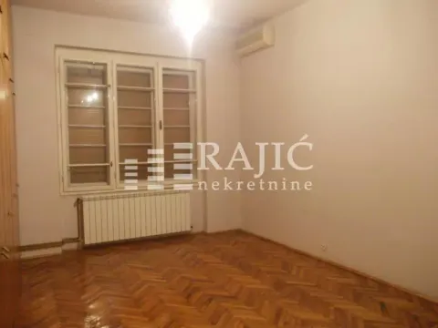 Empty room with parquet flooring and a window. - image 2