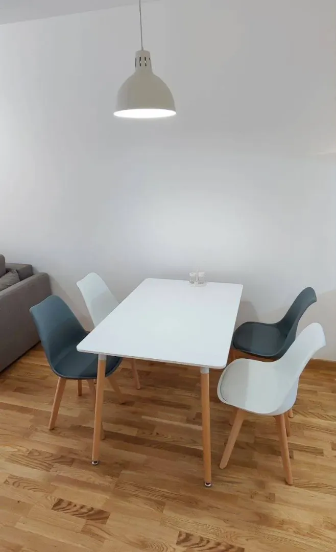 Trpezarija sa bijelim stolom i modernim stolicama.