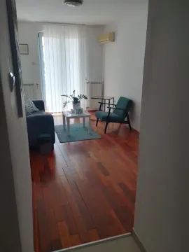 Pogled na dnevnu sobu sa garniturom i drvenim podom. - image 2