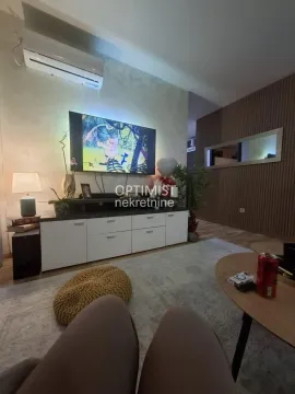 Dnevna soba sa televizorom, komodom i drvenim zidnim panelima. - image 15