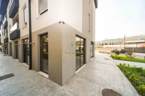 Exterior view of a modern residential building with commercial space on the ground floor. - image 8