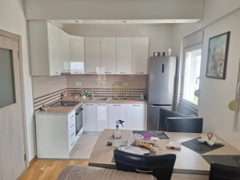 Kitchen equipped with white units and a refrigerator, with a dining table in the foreground. - image 5