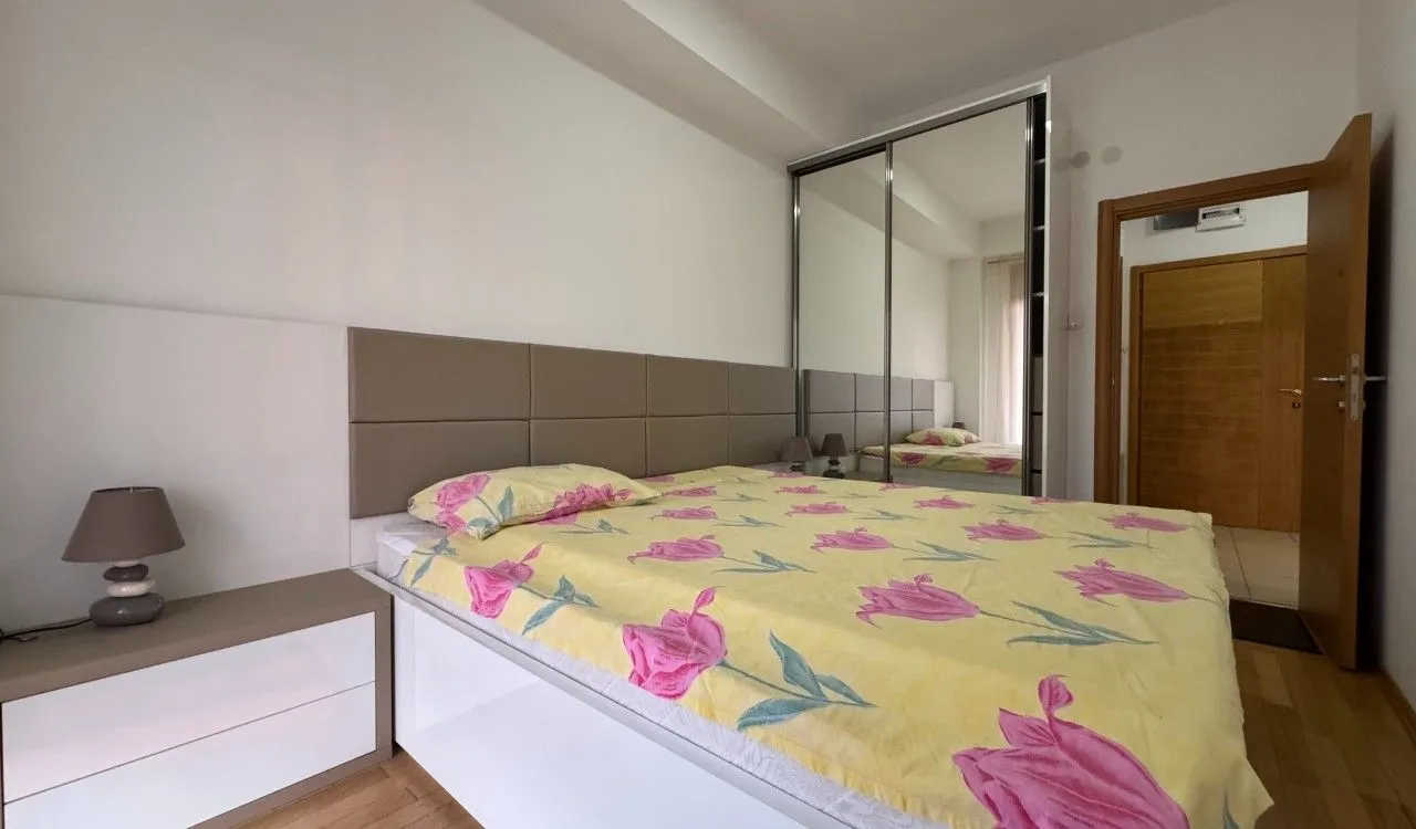 Bedroom with a double bed, nightstand, and fitted mirrored wardrobe.
