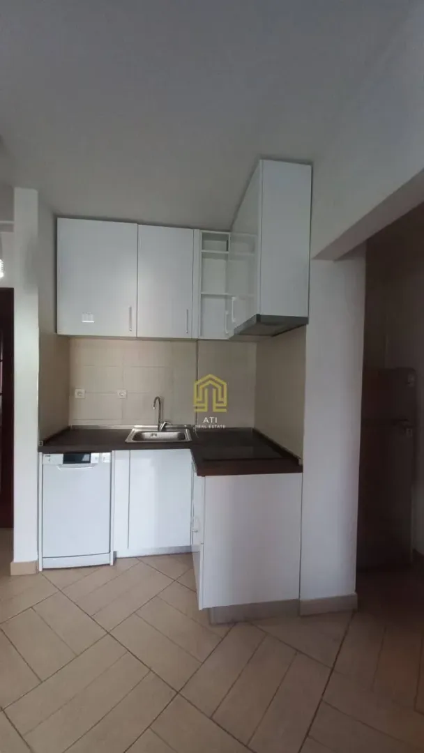Small kitchen with white cabinets and ceramic tiles.