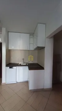 Small kitchen with white cabinets and ceramic tiles. - image 3
