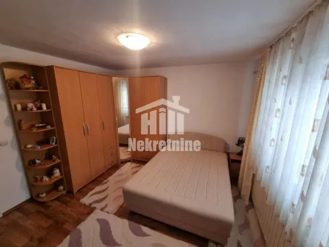 Nameštena spavaća soba sa bračnim krevetom, velikim drvenim ormarom i policama. - image 12