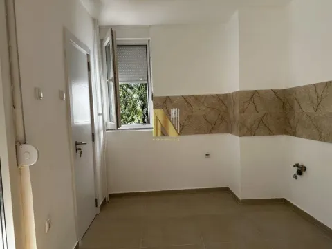 Manja prazna kuhinja sa pločicama na zidu i prozorom. - image 6